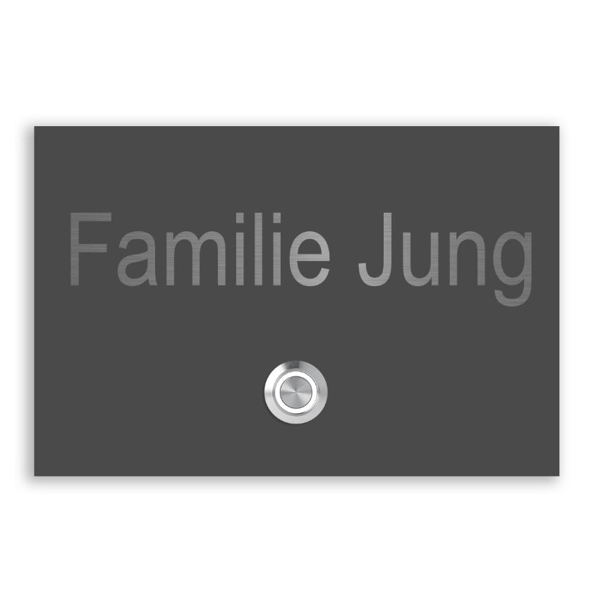 Dunkelgraue Klingelplatte mit silberner Schrift "Familie Jung" und Klingelknopf.