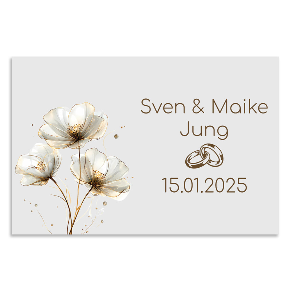 Personalisierbares Hochzeitsschild aus weiß pulverbeschichtetem V2A Edelstahl in 12 x 8 cm mit zarten Blüten, Eheringen und dem Namen „Sven & Maike Jung“ sowie Hochzeitsdatum – ideal als Erinnerung oder Geschenk.
