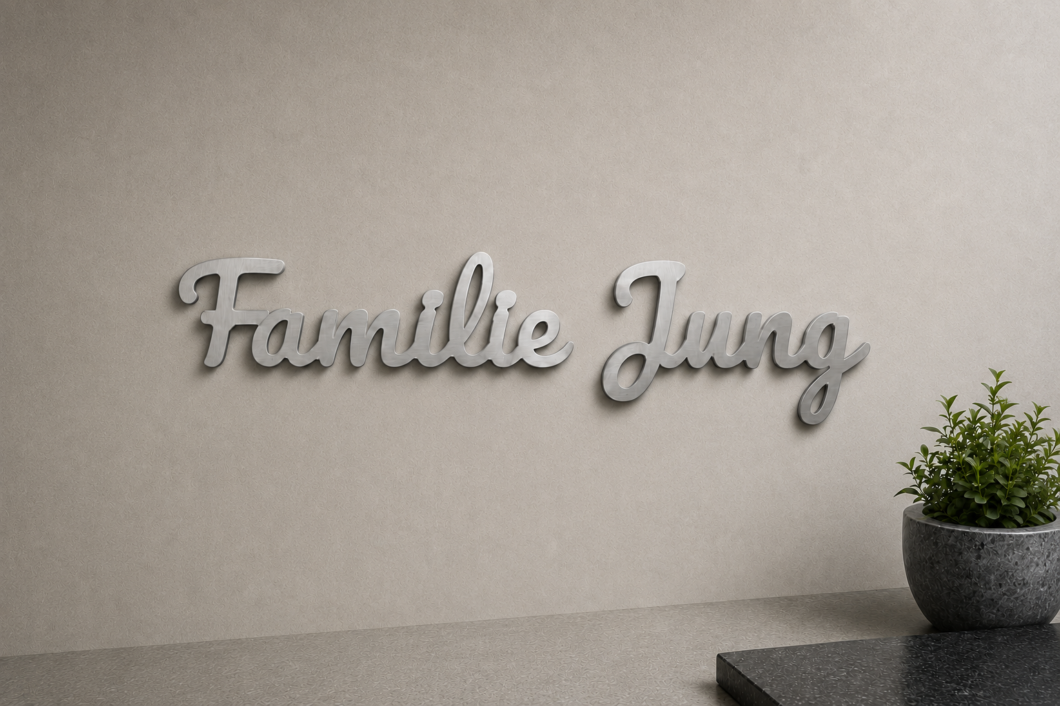 Personalisierter gebürsteter Edelstahl-Schriftzug mit Familiennamen an einer modernen Wand