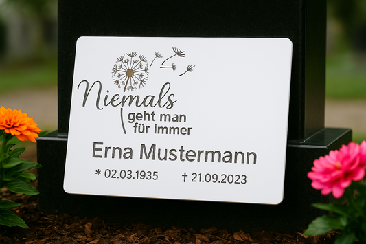 Weiße V2A Gedenktafel mit Laser-Gravur an Marmorplatte auf Friedhof mit Blumen